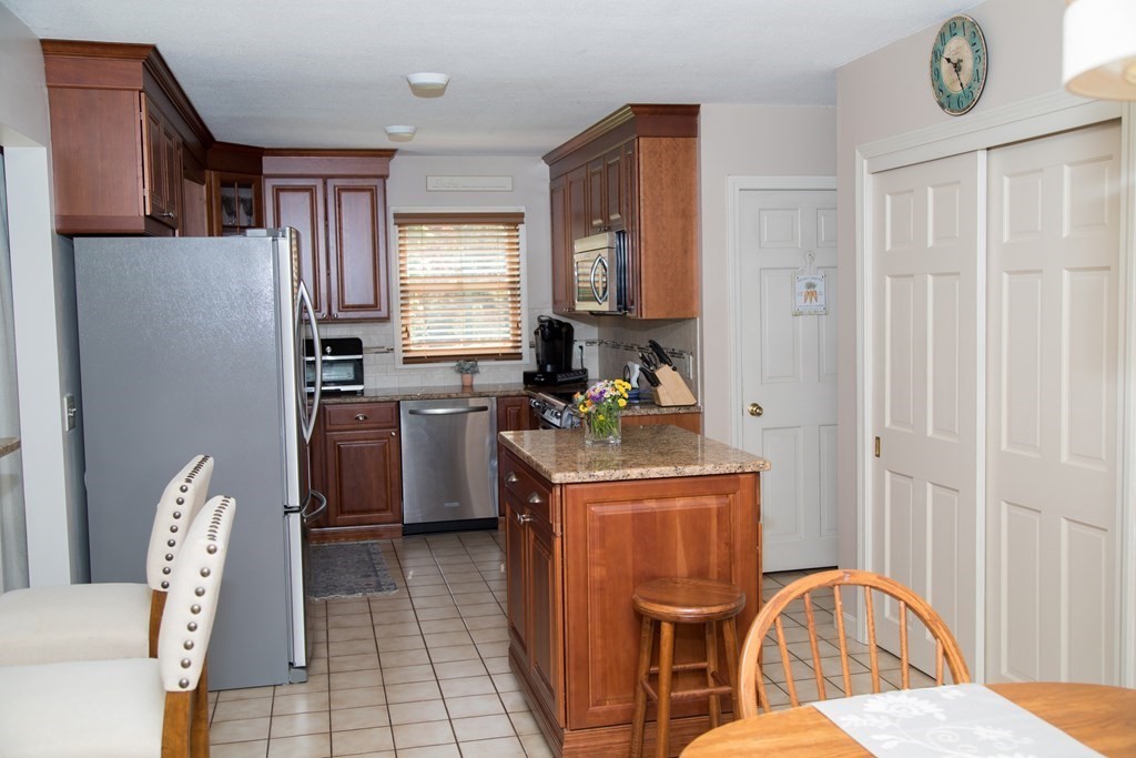 22 Deer Run Road West Springfield, MA 01089 - Photo 6 of 38 a kitchen with stainless steel appliances granite countertop a refrigerator a stove a sink dishwasher and wooden cabinets