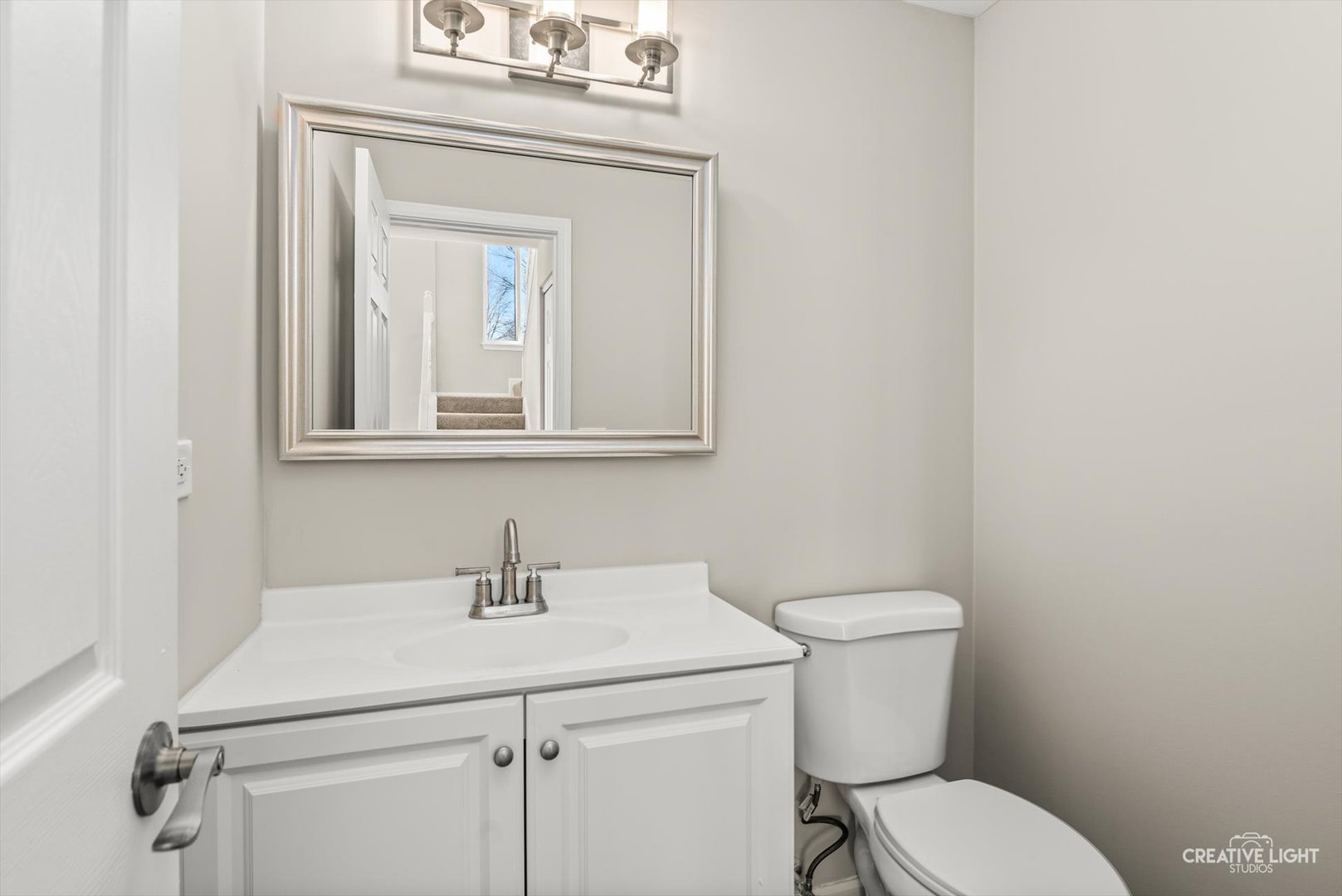 308 Alyssa Street Plano, IL 60545 - Photo 3 of 10 a bathroom with a toilet sink and mirror