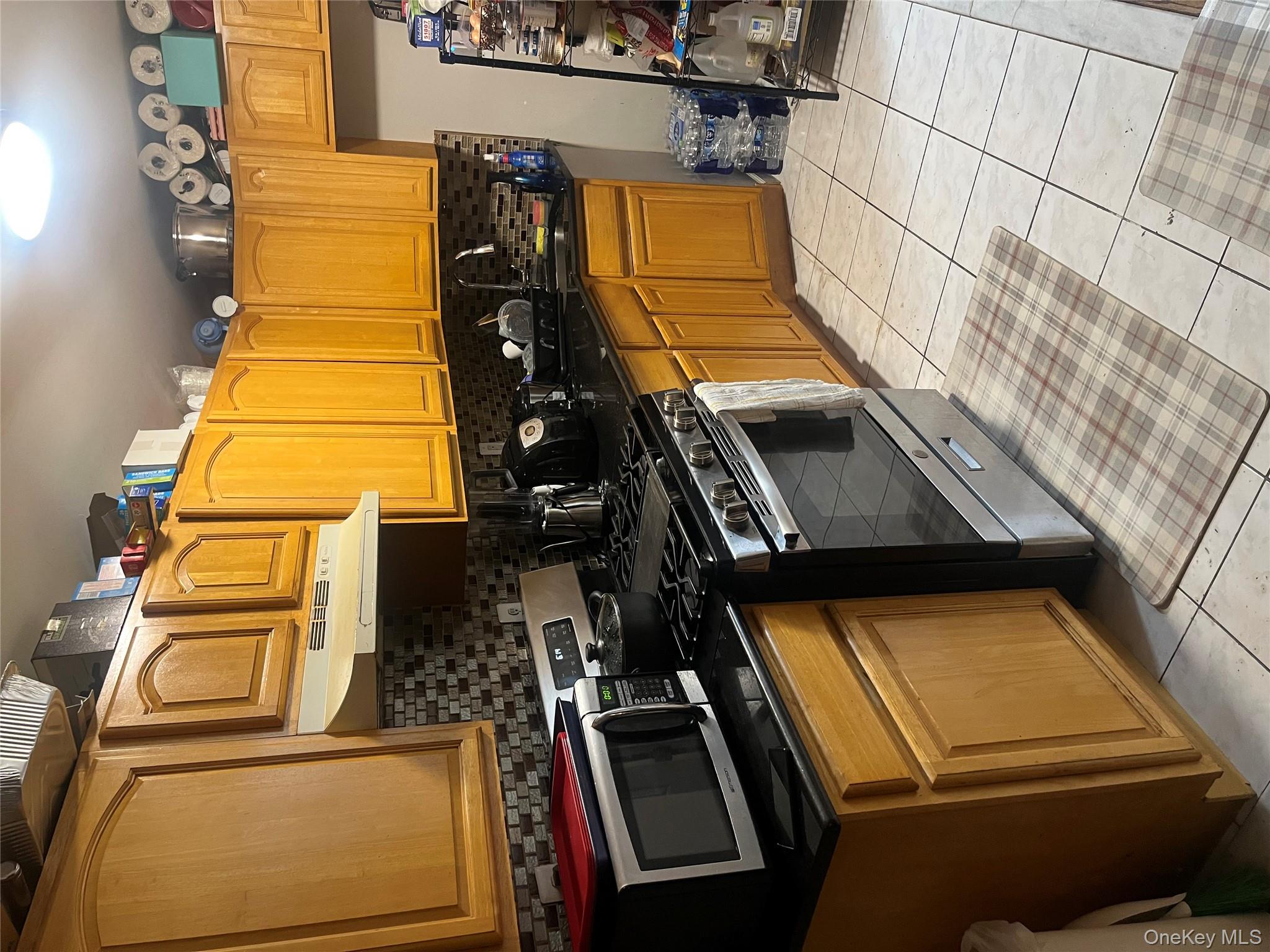 137-15 220th Place Queens, NY 11413 - Photo 14 of 28 a kitchen with stainless steel appliances a stove a sink and a microwave