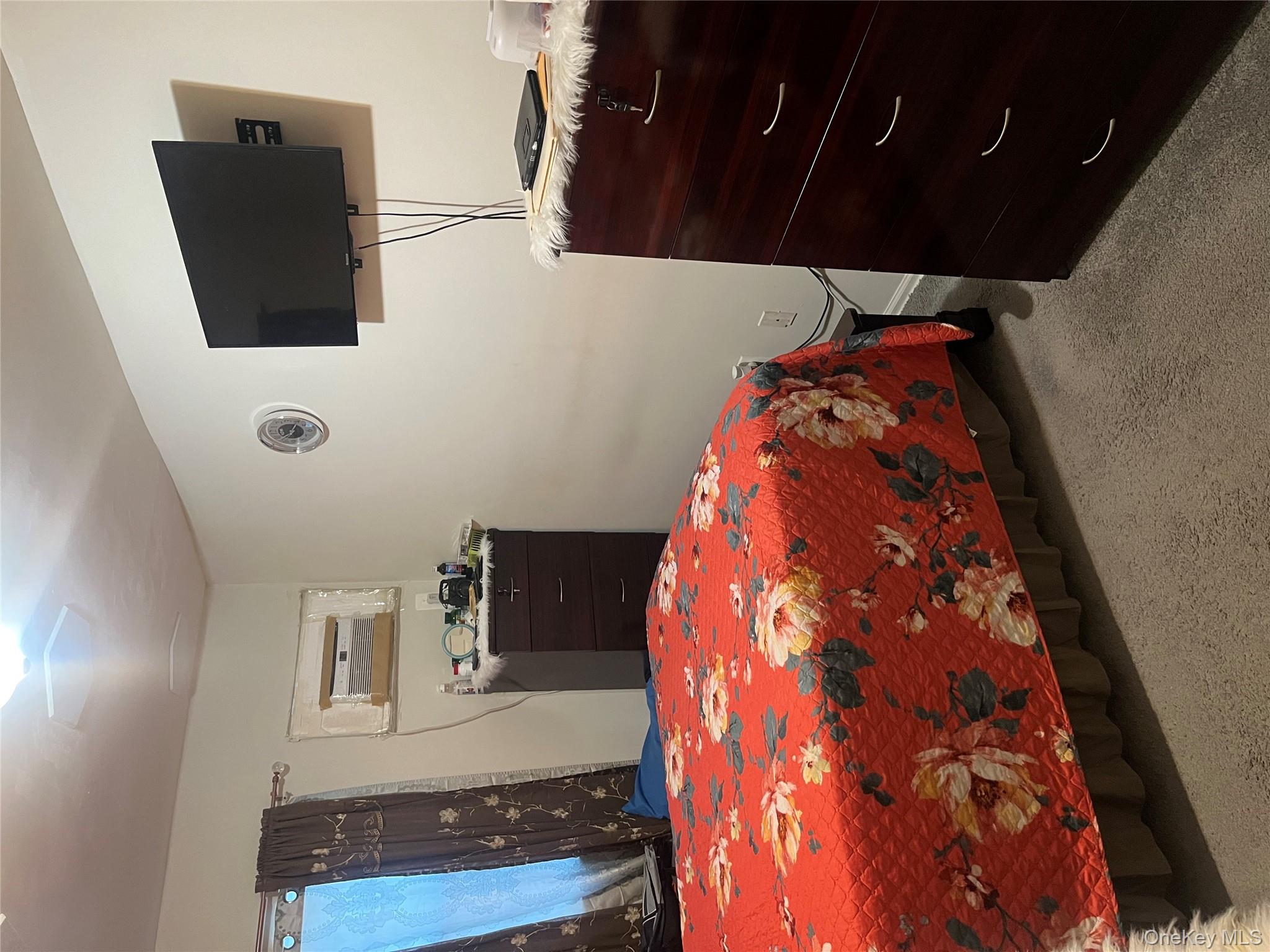 137-15 220th Place Queens, NY 11413 - Photo 9 of 28 a bedroom with a bed and a flat tv screen