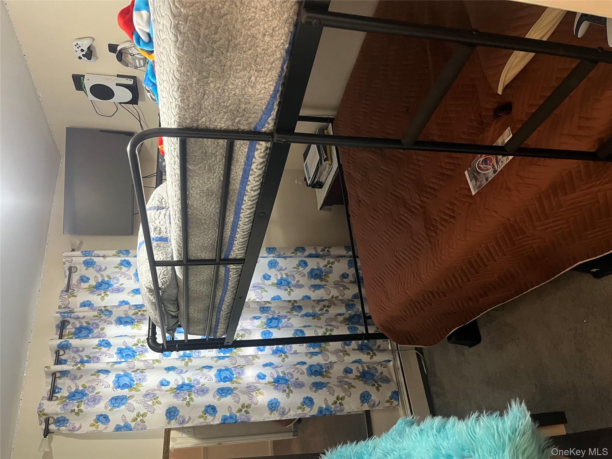 137-15 220th Place Queens, NY 11413 - Photo 10 of 28 a bedroom with a bed and a window