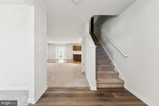 a view of entryway and hall with wooden floor