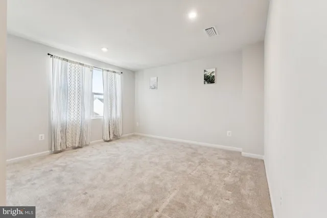 an empty room with a ceiling fan and window
