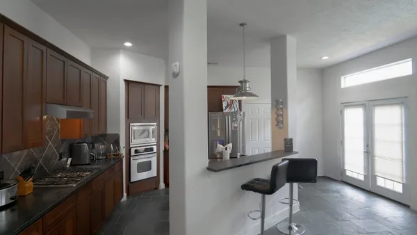 a kitchen with stainless steel appliances kitchen island granite countertop a refrigerator and a stove top oven