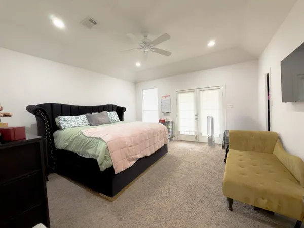 a spacious bedroom with a bed and a couch