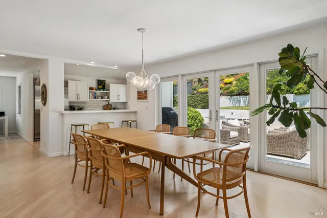 a view of a dining room and livingroom with furniture wooden floor a chandelier