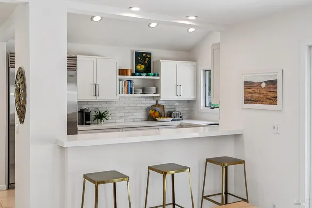 a kitchen with stainless steel appliances kitchen island a refrigerator and cabinets