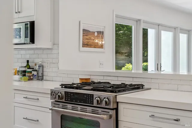 a white stove top oven sitting inside of a kitchen