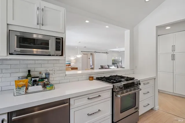 a kitchen with stainless steel appliances white cabinets and stove