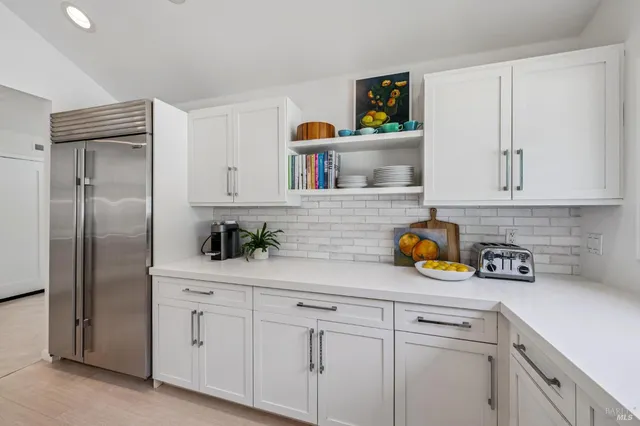 a kitchen with stainless steel appliances white cabinets and a refrigerator