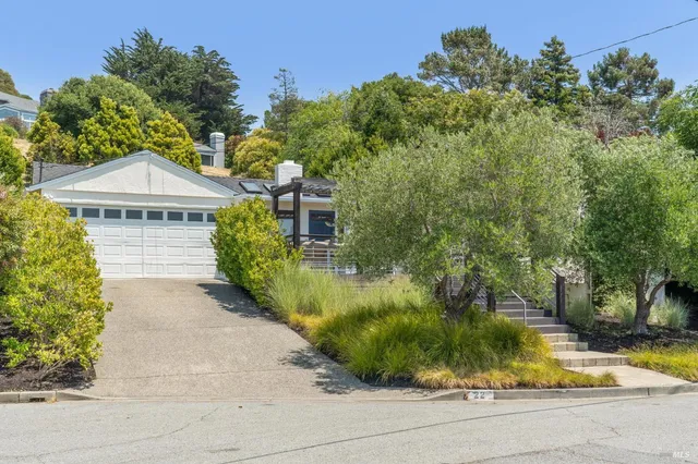 a view of a house with a yard and potted plants