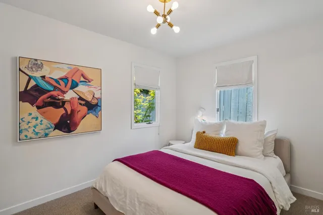 a bedroom with a bed and a painting on the wall