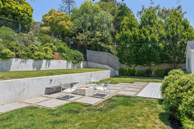 a view of a backyard with plants and outdoor seating