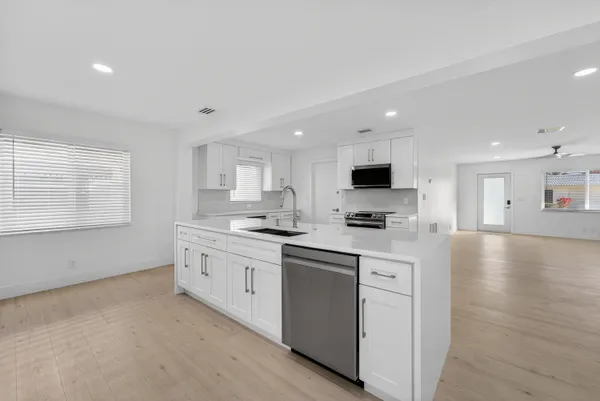 a kitchen with stainless steel appliances granite countertop a sink and cabinets