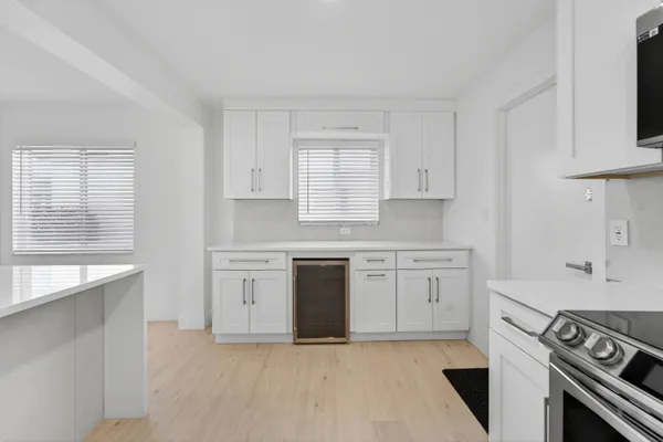 a kitchen with granite countertop white cabinets sink and stainless steel appliances
