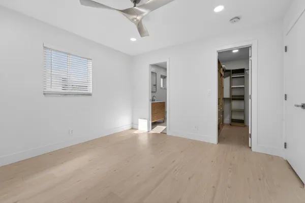 an empty room with closet and windows