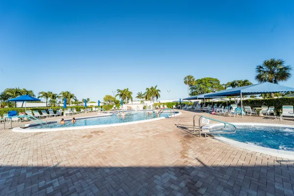 a view of a swimming pool with a lawn chairs and potted plants