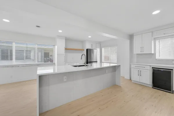 a large kitchen with stainless steel appliances a sink dishwasher a stove and a refrigerator