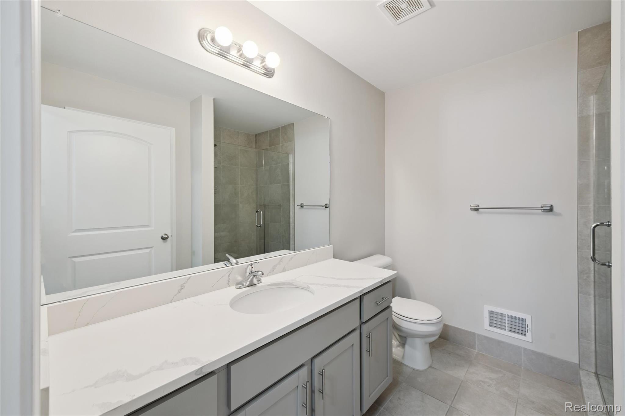 816 Nelson's Ridge Drive Howell, MI 48843 - Photo 18 of 36 Primary bath featuring quartz vanity and tiled walk-in shower.