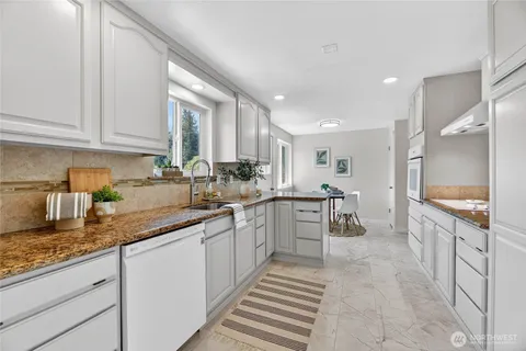 a kitchen with granite countertop a sink a counter top space and appliances