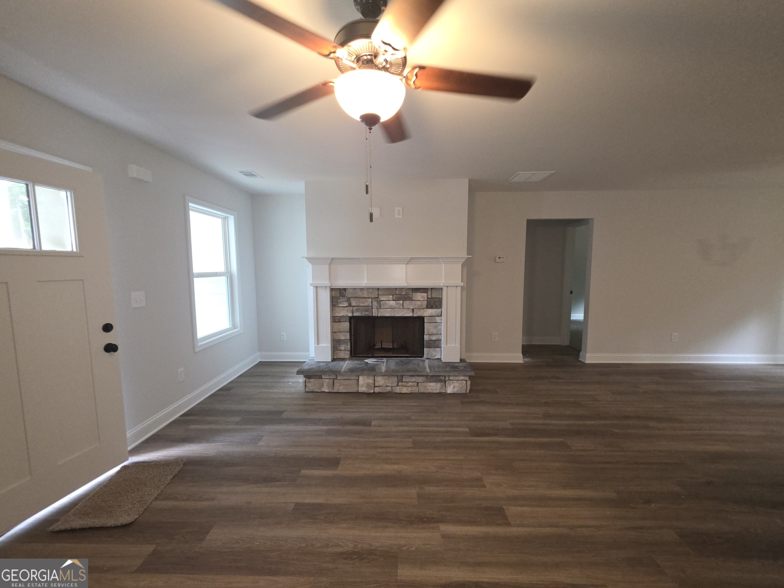 546 Hargrove Lake Road, Unit 2B Arnoldsville, GA 30619 - Photo 4 of 14 a view of an empty room with wooden floor fireplace and a window