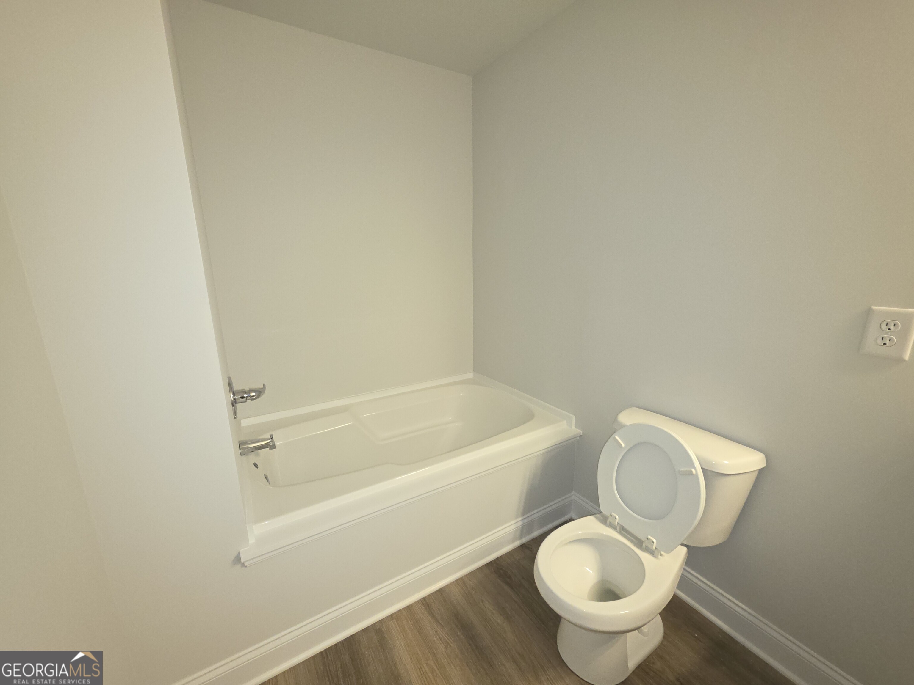 546 Hargrove Lake Road, Unit 2B Arnoldsville, GA 30619 - Photo 9 of 14 a white toilet sitting next to a bath tub