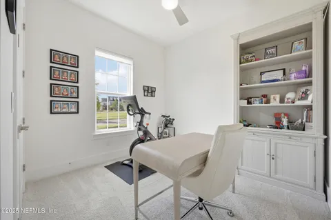 a view of a workspace with furniture and a window