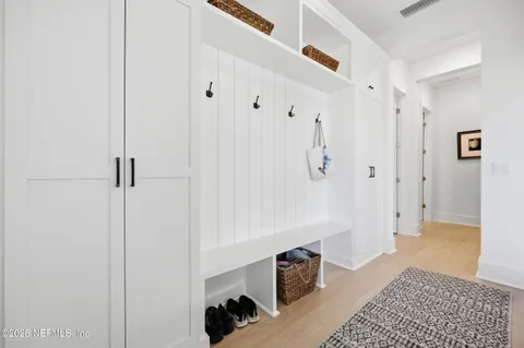a view of a bedroom with wooden floor and a bathroom