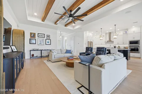 a living room with furniture kitchen view and a flat screen tv