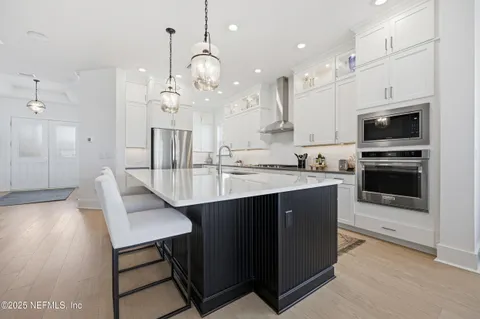an open kitchen with granite countertop a sink cabinets and stainless steel appliances