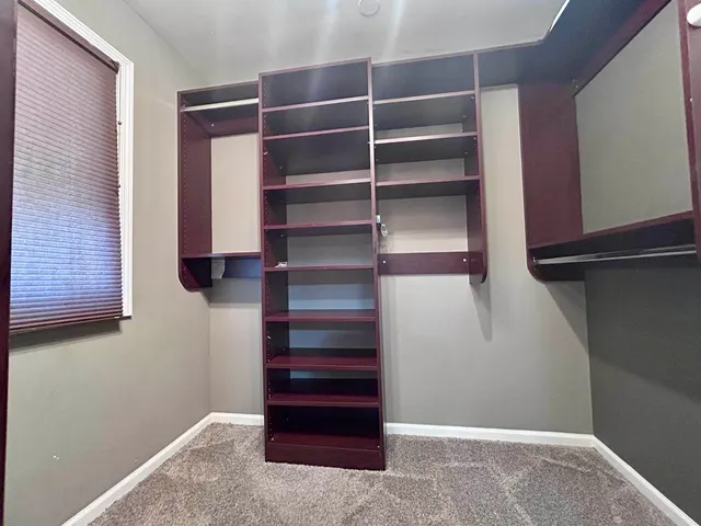 a view of walk in closet with empty racks