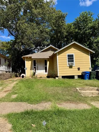 a front view of a house with a garden and yard