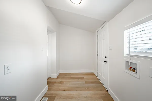 a view of a hallway with wooden floor and entryway