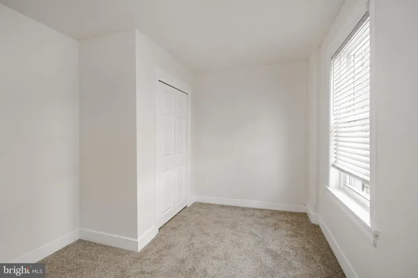 an empty room with windows and closet