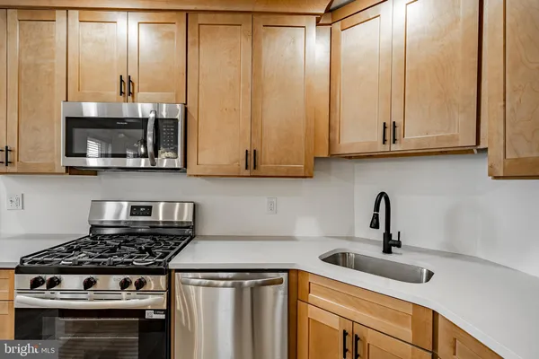 a kitchen with stainless steel appliances a stove a sink and cabinets