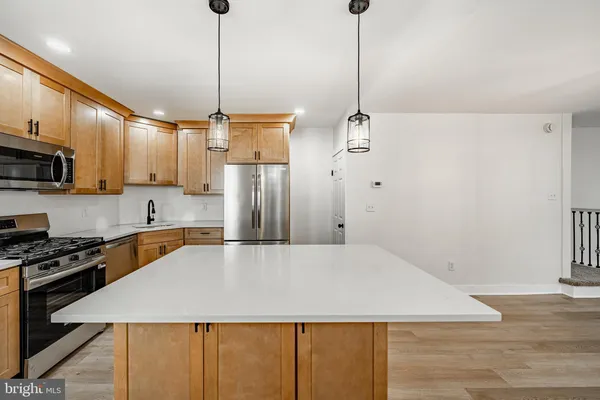 a large kitchen with stainless steel appliances granite countertop a sink a stove and a refrigerator