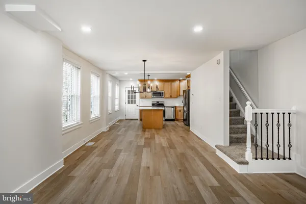 a large kitchen with wooden floor and a large window