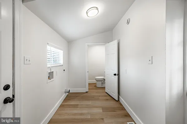 a view of a room with wooden floor and a bathroom