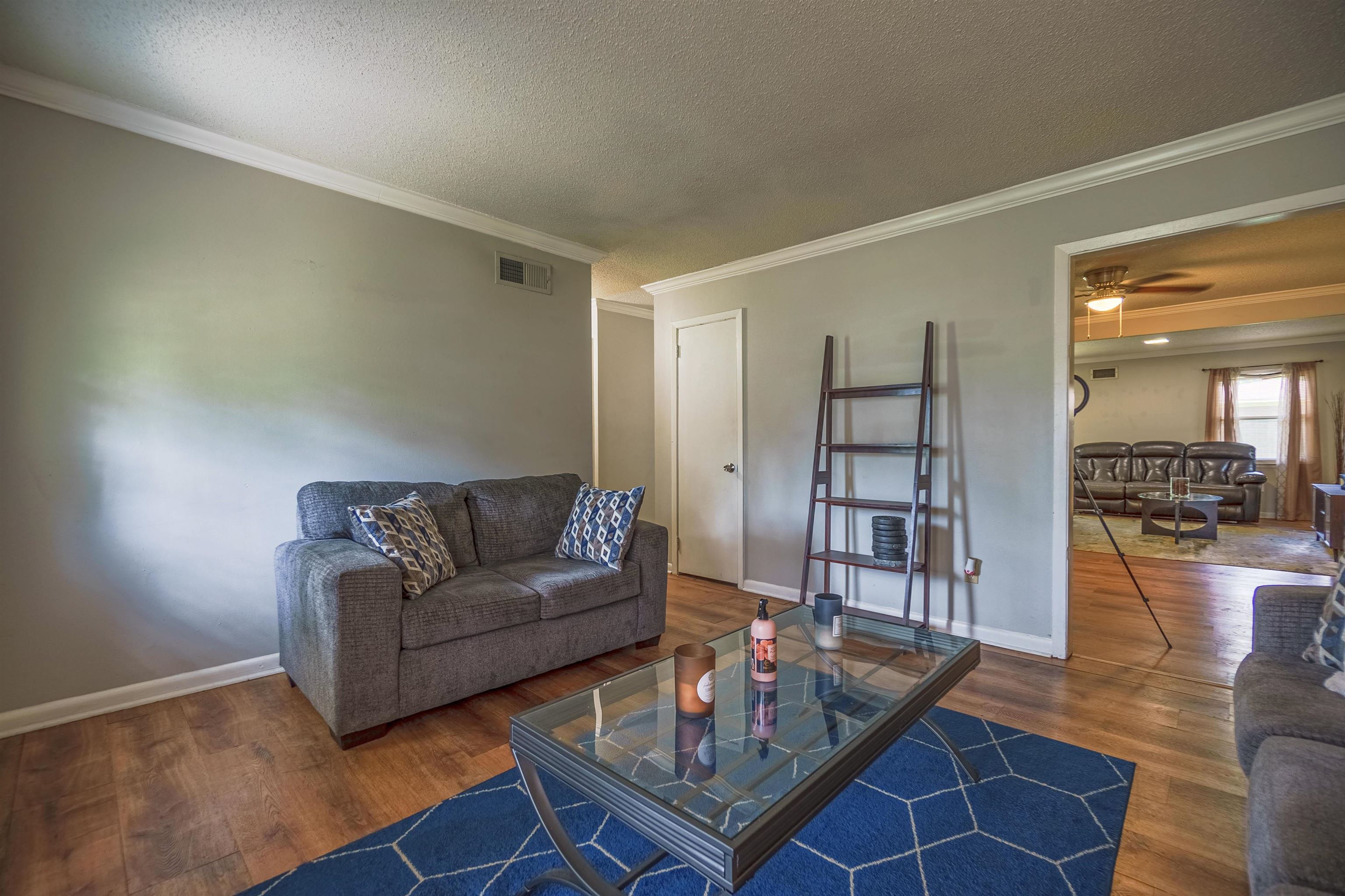 1950 Victoria Road Memphis, TN 38116 - Photo 17 of 25 Living area with crown molding, ceiling fan, a textured ceiling, and dark wood-type flooring