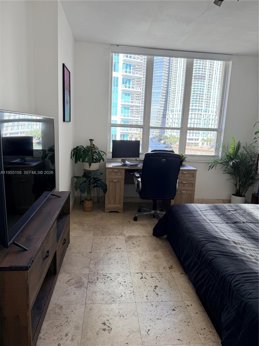 888 Brickell Key Drive, Unit 701 Miami, FL 33131 - Photo 13 of 20 a bedroom with furniture and a flat screen tv