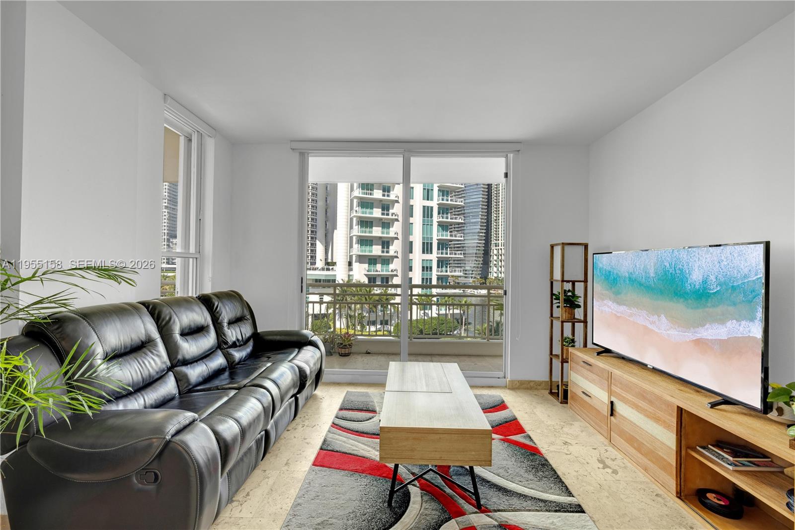 888 Brickell Key Drive, Unit 701 Miami, FL 33131 - Photo 16 of 20 a living room with furniture and a flat screen tv