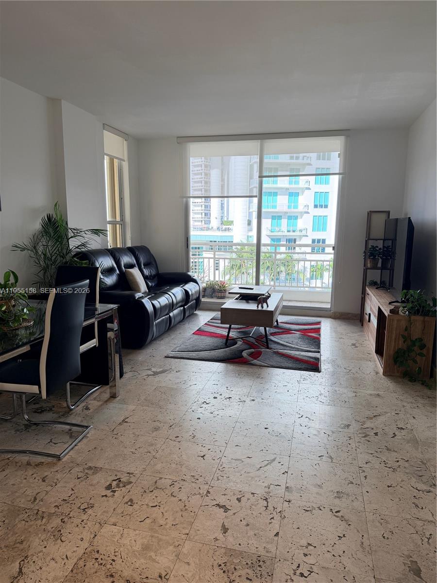 888 Brickell Key Drive, Unit 701 Miami, FL 33131 - Photo 19 of 20 a living room with furniture a flat screen tv and a window