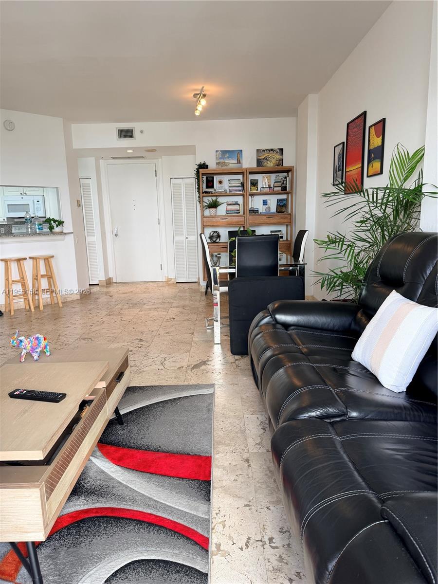 888 Brickell Key Drive, Unit 701 Miami, FL 33131 - Photo 7 of 20 a living room with furniture and flat screen tv