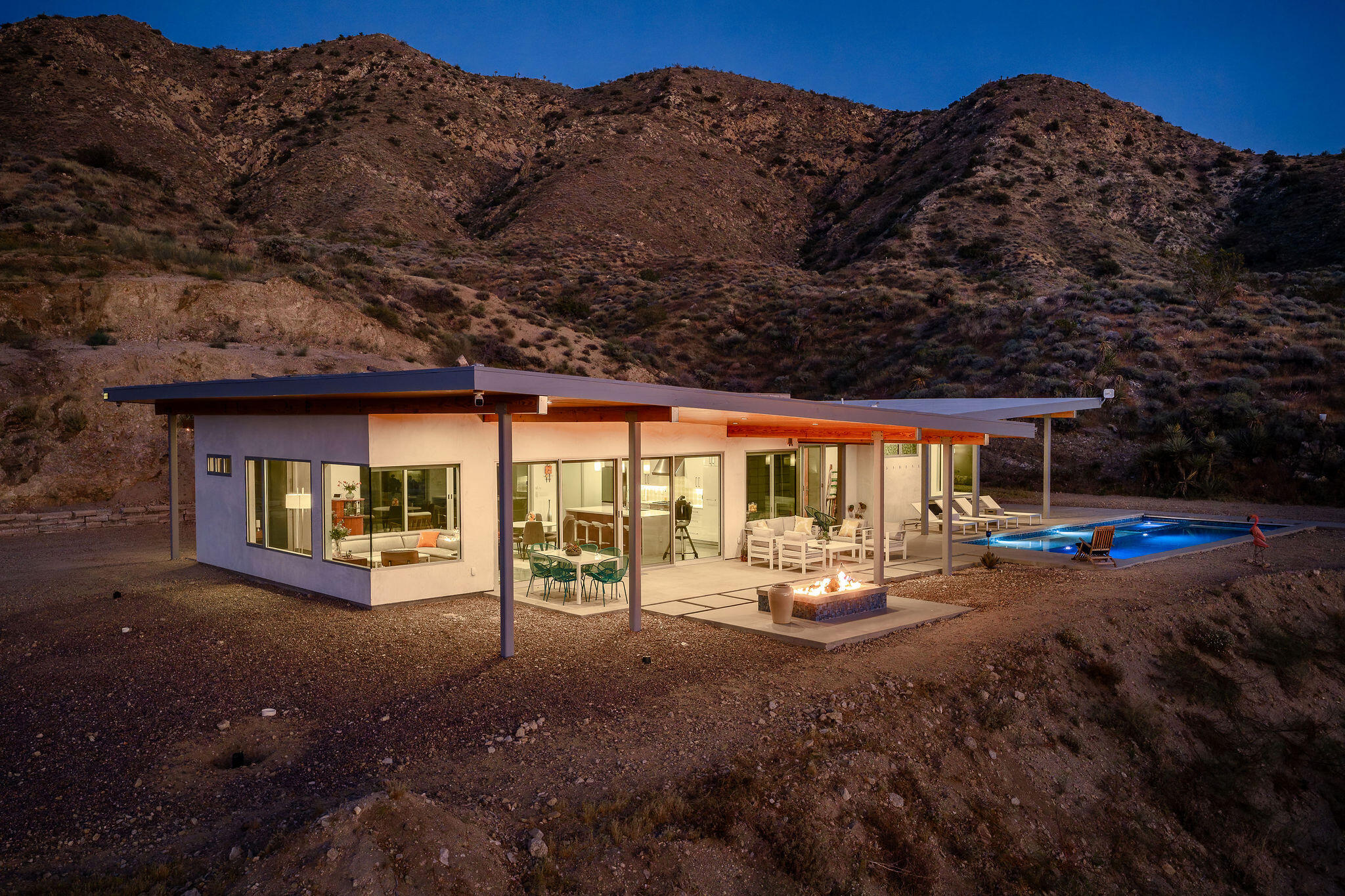 53145 Northridge Road Morongo Valley, CA 92256 - Photo 48 of 48 a view of a patio with table and chairs potted plants and floor to ceiling window