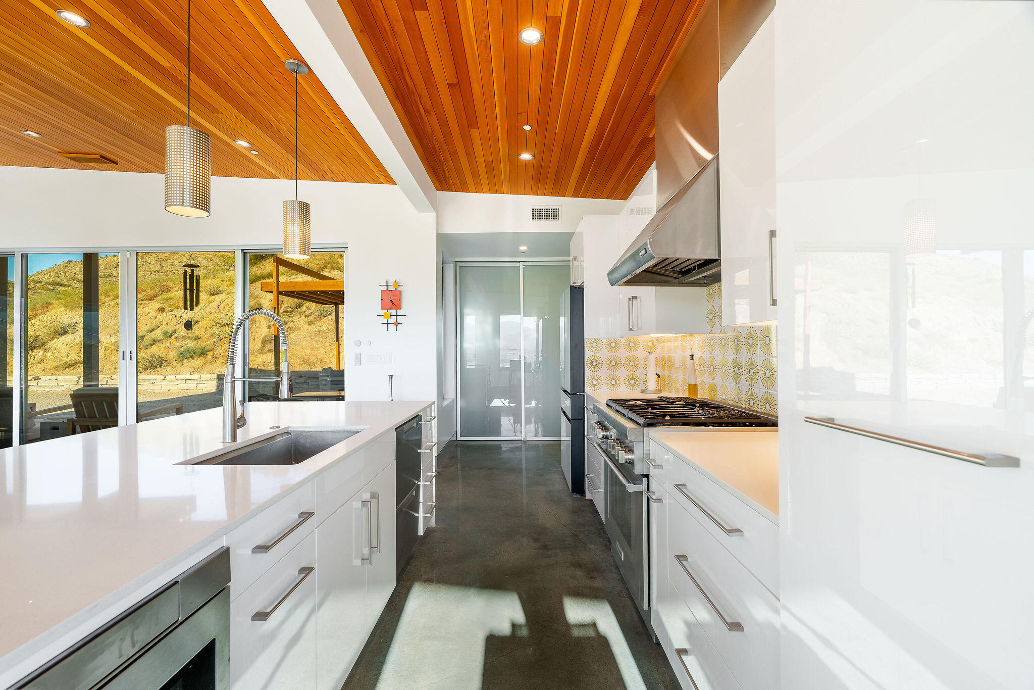 53145 Northridge Road Morongo Valley, CA 92256 - Photo 10 of 48 a large kitchen with stainless steel appliances granite countertop a sink and cabinets with a large window