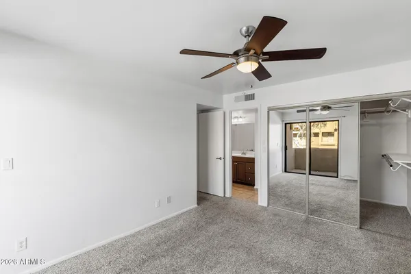 an empty room with closet and windows