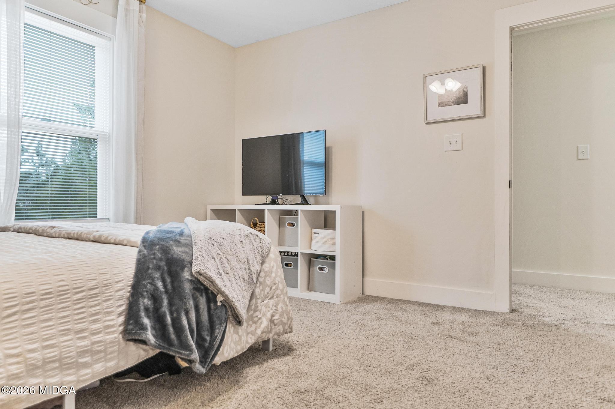 155 Creekside Lane Forsyth, GA 31029 - Photo 29 of 43 a bedroom with a bed and a flat screen tv