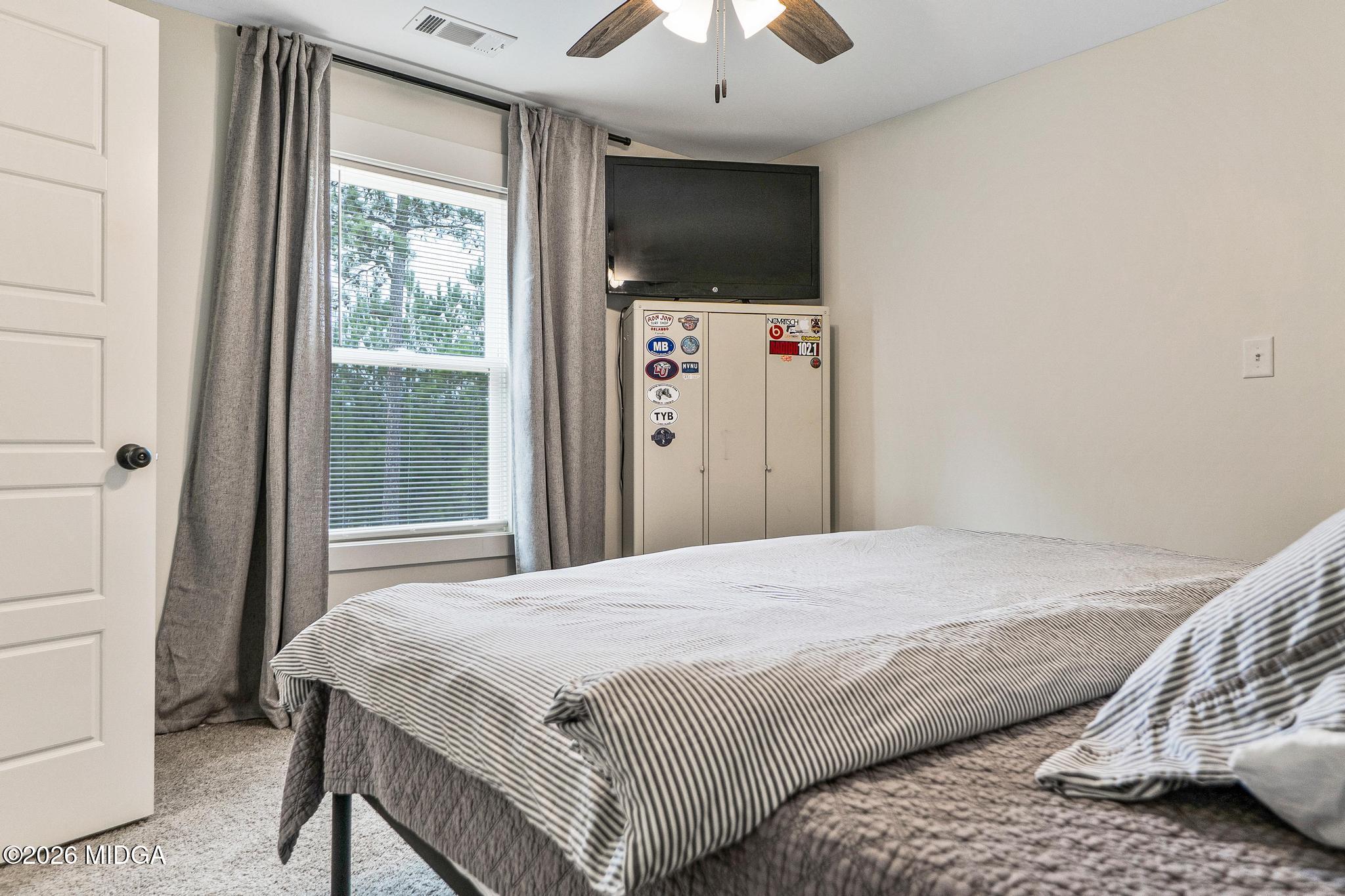 155 Creekside Lane Forsyth, GA 31029 - Photo 32 of 43 a bedroom with a bed and a flat screen tv