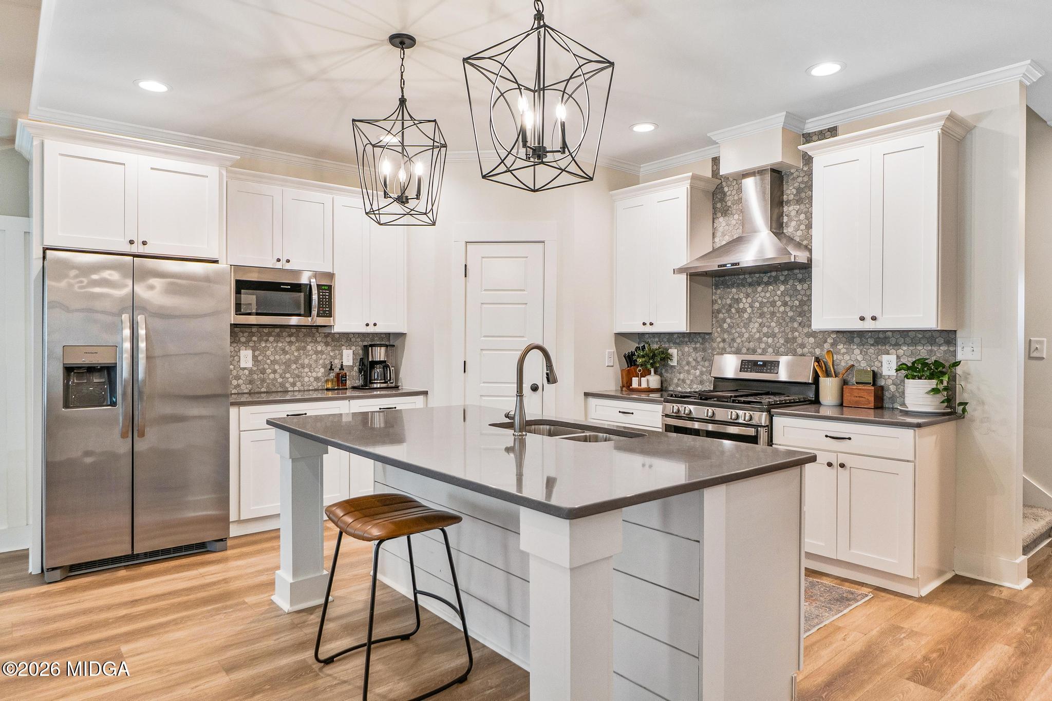 155 Creekside Lane Forsyth, GA 31029 - Photo 7 of 43 a kitchen with stainless steel appliances granite countertop a sink a stove a refrigerator cabinets and chairs