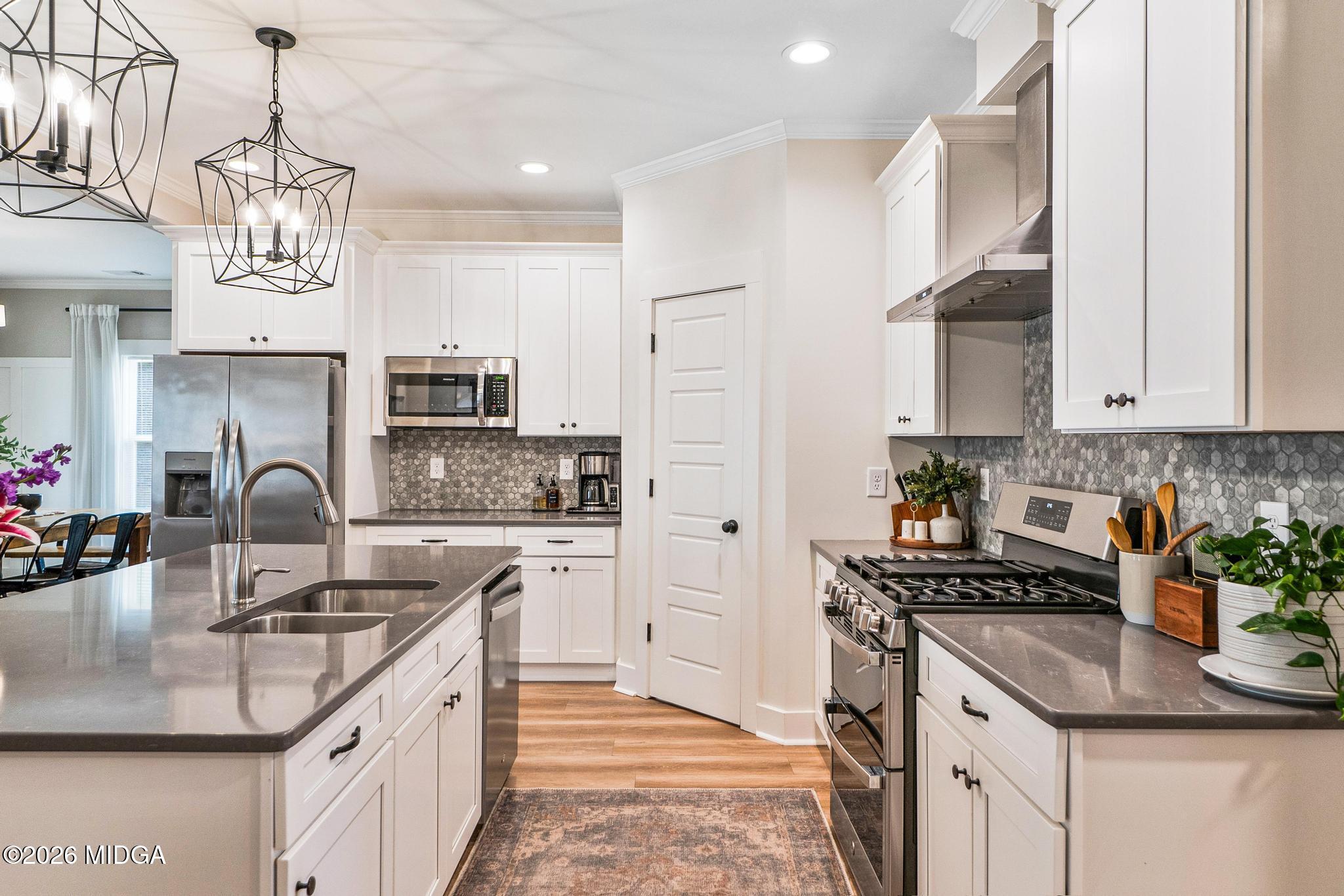 155 Creekside Lane Forsyth, GA 31029 - Photo 8 of 43 a kitchen with kitchen island granite countertop a sink a counter space cabinets and stainless steel appliances